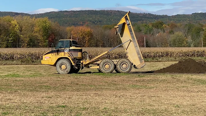 Caterpillar 725 Articulated Dump Truck dumping soil