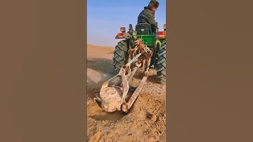Tractor uses auger attachment to dig hole for tree planting