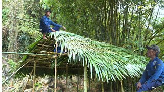 Roofing the bamboo house with palm tree leaves