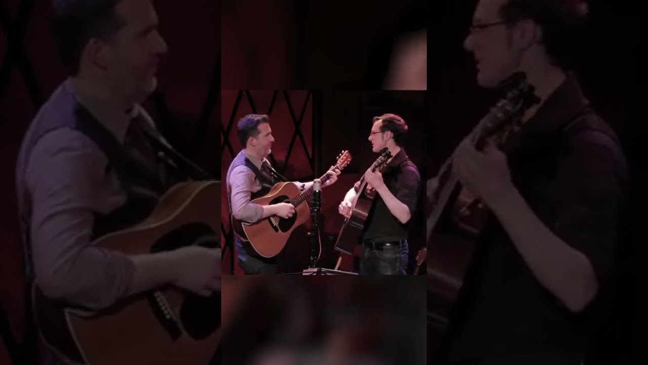 Bryan Sutton and Michael Daves joking on stage.