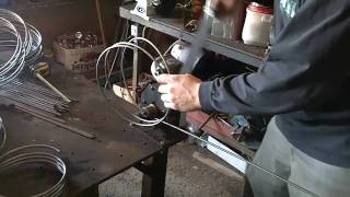 WORKING IN THE WELDING SHOP MAKING STEEL RINGS FOR FLOWER POT STANDS.