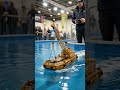 Tiny RC WWII destroyer weaving through a real rocky coastal inlet like a full-scale warship