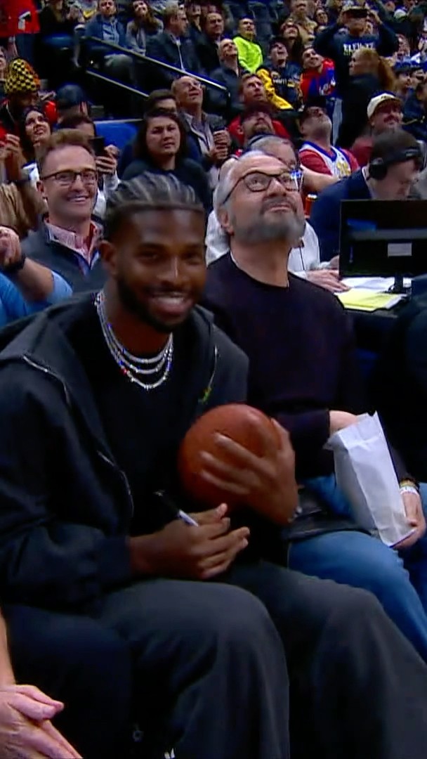Sheduer Sanders sitting courtside in Denver signing a football!