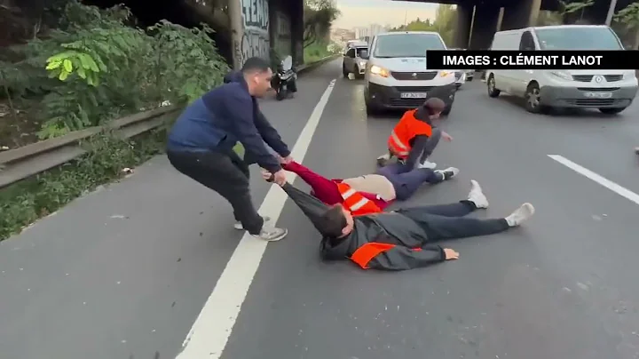 Furious drivers physically drag activists off a bu...
