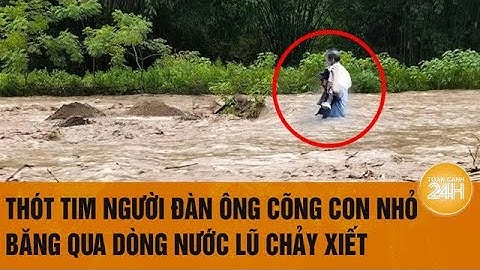 Thót tim người đàn ông cõng con nhỏ băng qua dòng nước lũ chảy xiết