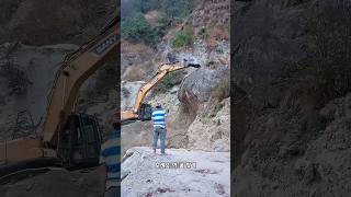 산에서 떨어진 거대한 바위를 치운 굴착기 기사