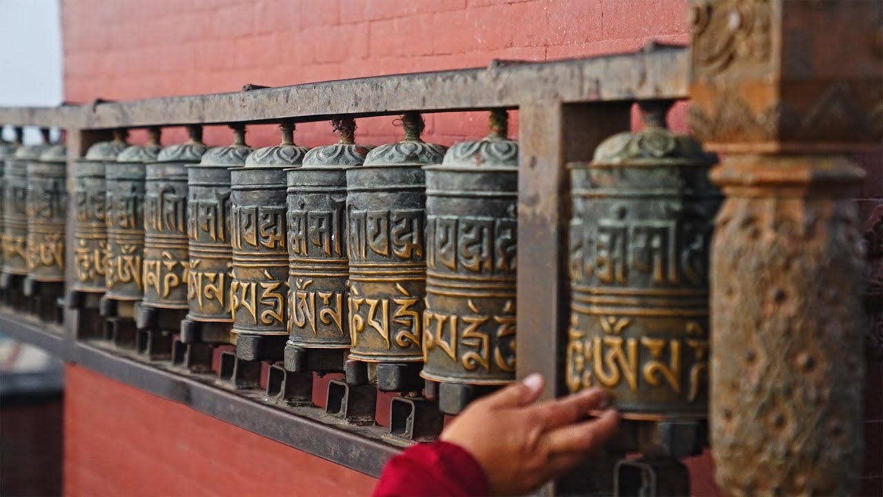 Woman spinning Buddhist prayer drums or prayer wheels in slow motion, Kathmandu, Nepal