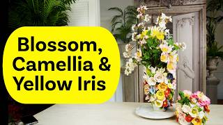 A Floral Design Of Spring Blossom, Camelia And Yellow Iris
