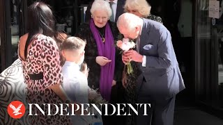 King and Queen exchange flowers and gifts with children as Charles resumes public duties