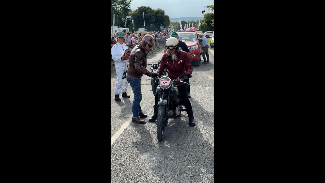 Man helps woman start her '38 Scott at hill climb, then they go