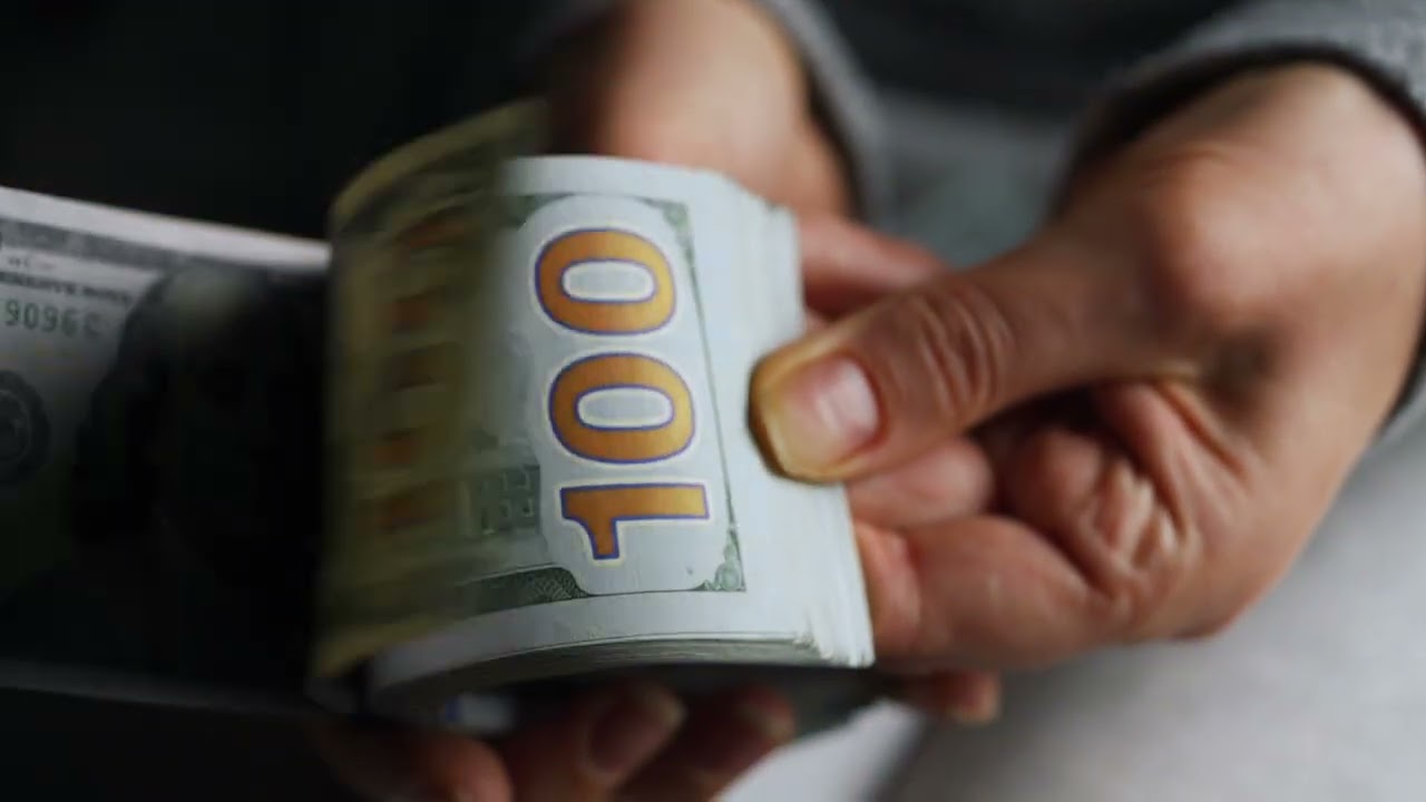 ands checks us dollar bills or counting in cash against the backdrop of police car lights