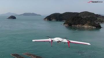 VTOL fixed-wing MILVUS flies over Korean national park shore.
