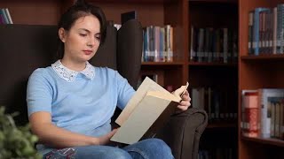 Woman Reads In Library Stock Video