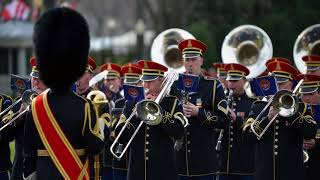 A looping marching band track, full of brass instruments and military
percussion – the type music you would hear at jamboree, carnival,
sporting event o...