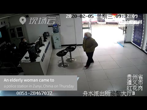 Elderly woman hands over stack of cash to police officers in Zunyi, China