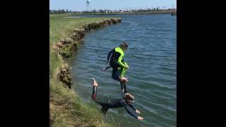 Boy gets tripped up by dog when jumping into lake
