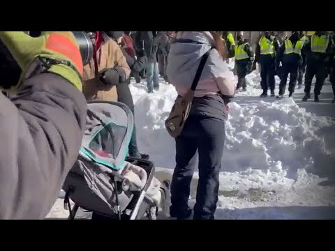 Protester with baby stands in the way of police | Over 100 arrested in Ottawa demonstrations