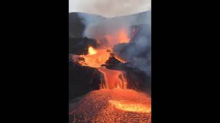 A photograph of a volcanic landscape with flowing lava, emphasizing its raw power and dramatic #volc