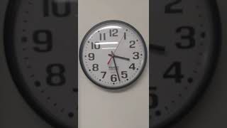 wall clock passing time in one minute. long sweeps of the second hand and clicking of the mechanism