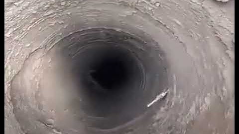 Chinese man singing into a hole in the ground and hitting someone in the head with ice as they reply