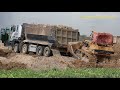 Dump truck and Bulldozer working - dump trucks unloading soil and bulldozer pushing soil