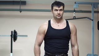 A Man in a Black Singlet Is Training Biceps with Dumbbells | Stock Footage - Videohive