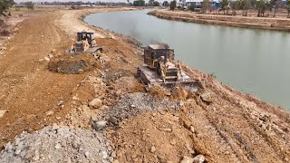 Beautiful view of the road construction process along the canal by Komatsu Dozer with Dump Truck Co-