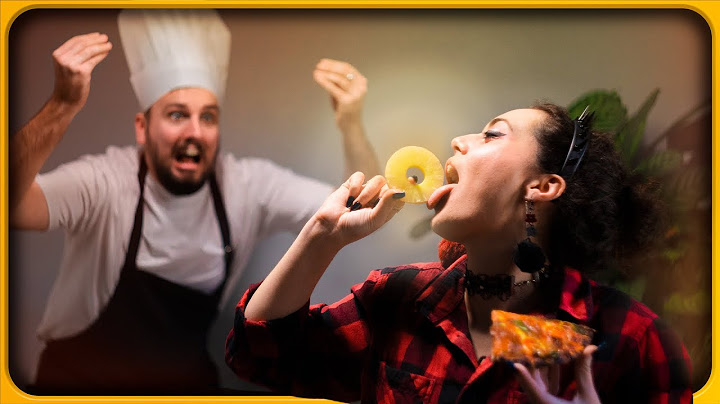 Putting pineapple on pizza in front of an Italian