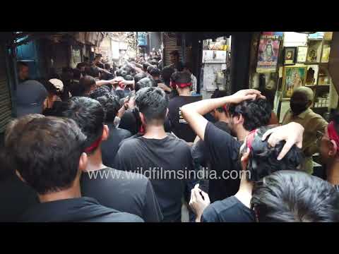 Crowded Muharram procession moves through a narrow street