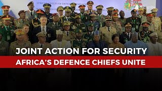 A diverse group of security officials and military leaders from various African nations stand together in a formal gathering, emphasizing unity and cooperation in defense efforts.