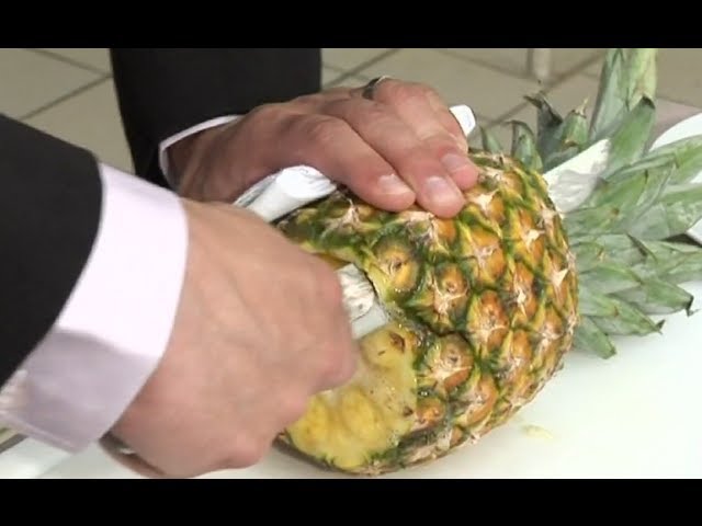 Couper une ananas dans une bol et sur une Coupe planche avec une