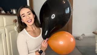 Blowing Up Orange And Black Balloons