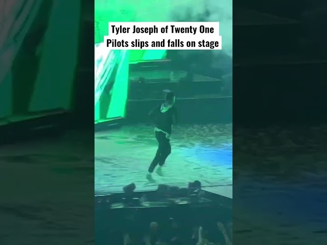 Tyler Joseph of @twentyonepilots  slips and falls on stage class=
