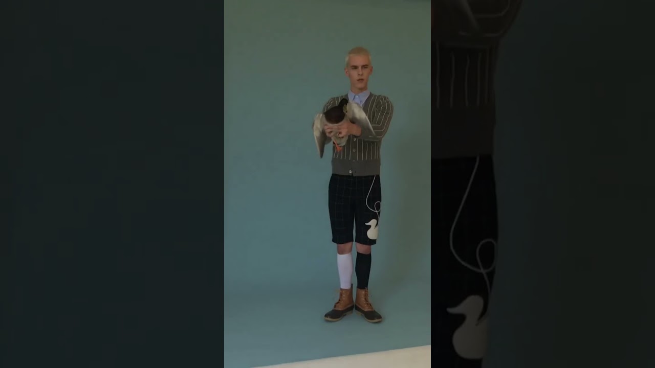 Male model strikes a pose with our feathered friend 🦆 #pawsitivelyfamous #bts #thombrowne