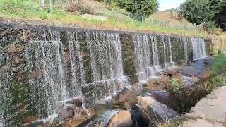 Cascada en muro de pequeño embalse en el paseo del río Lagares en Vigo