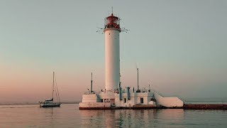 Вдоль морского побережья Одессы на закате. Оранжевое небо и тихий шум воды