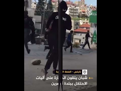 شبان يلقون الحجارة على آليات الاحتلال خلال اقتحامها بلدة أوصرين جنوب نابلس