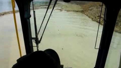 Excavator digging in a pond