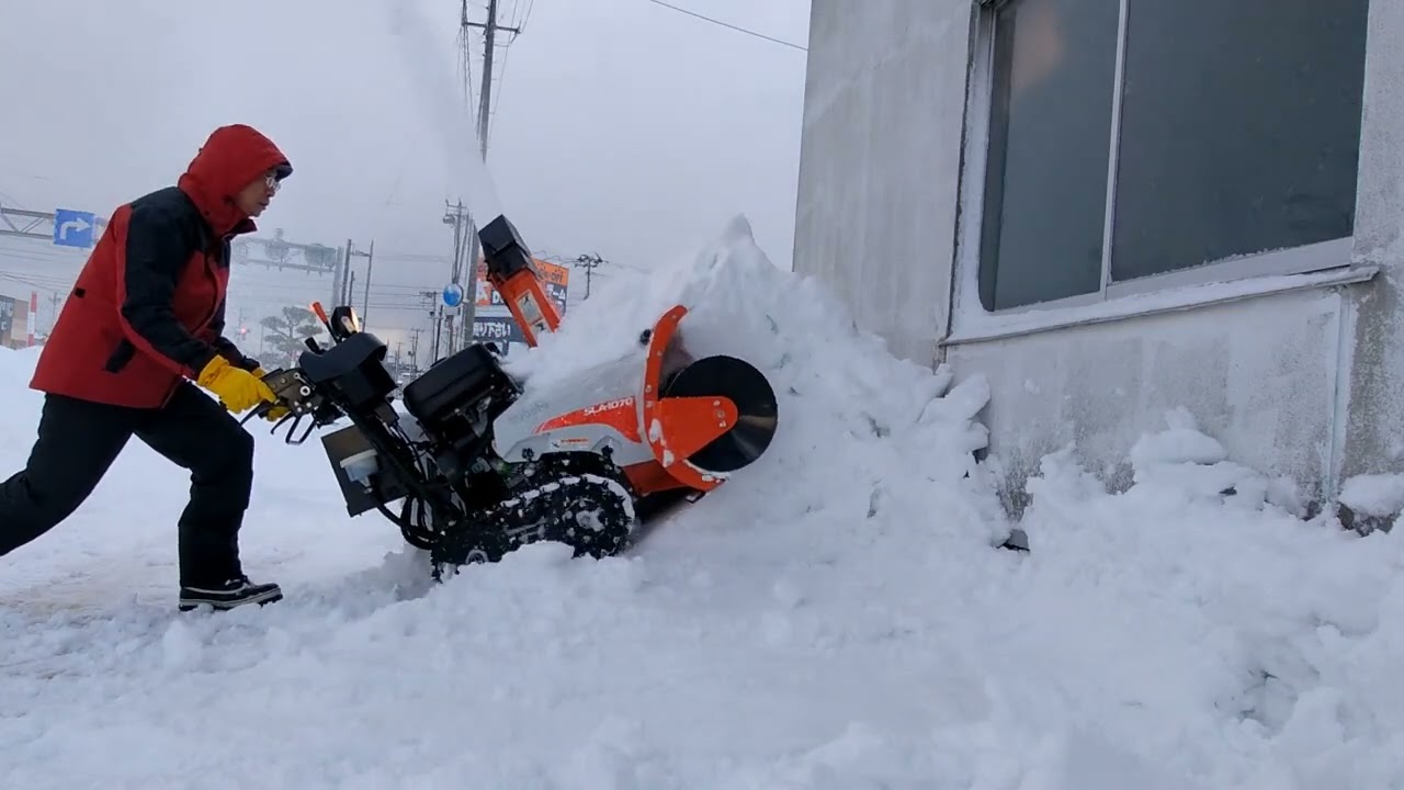 屋根からの落雪を除雪機で飛ばす