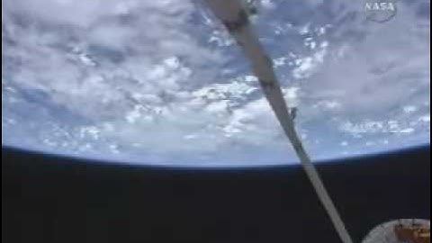 Shuttle Atalantis robotic arm prepares for camera survey of shuttle crew quarters.