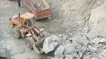 Heavy machine rocks loading in action: caterpillar loader big rocks loading trolleys and dampers#cat
