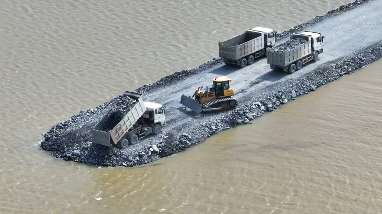 It's amazing how much earth and stones are poured to build a road over water.dozer &Truck 25Ton