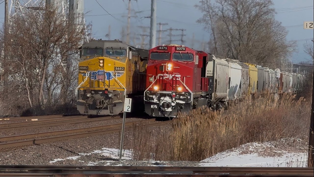 Union Pacific coal train meets CPKC 9375 the of the CPKC livery with its engine panel open