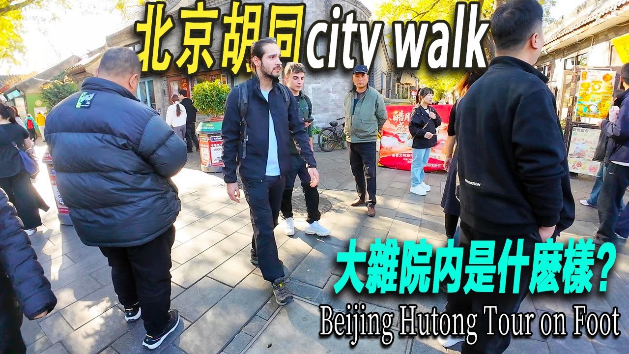 走進北京老城區的胡同，來一次胡同city walk。許多國内外游客。很多年輕人在胡同裏打卡拍照。以前的深宅大院，新中國之後被收回國有、十年艱難時期被抄家、76年地震期间搭建地震棚，形成了現在的大雜院。
