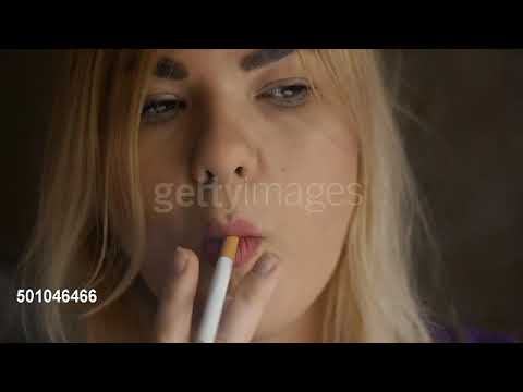 Pretty blonde girl smoking a cigarette. Slow motion