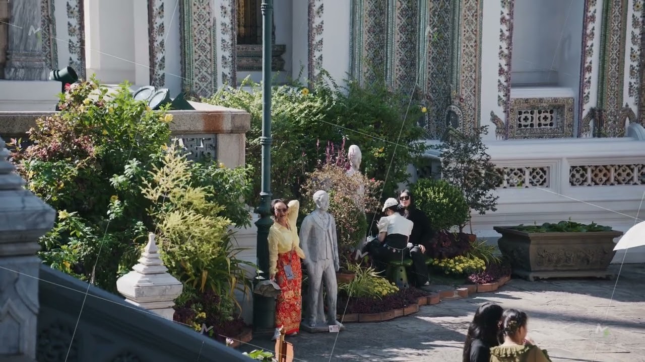 Tourists in traditional and modern attire explore beautiful grounds and architecture of the Grand