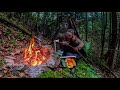 Building a shelter cooking over open fire while heavy rain