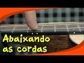 Abaixando as cordas de um violão folk