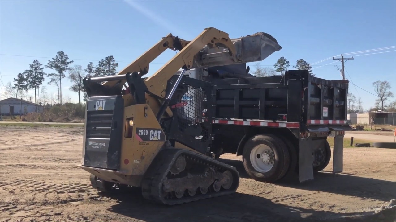 Cat 259D skid steer loading Mack dump truck YouTube