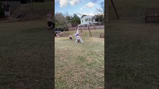 Girl does several backflip in yard and lands on little boy